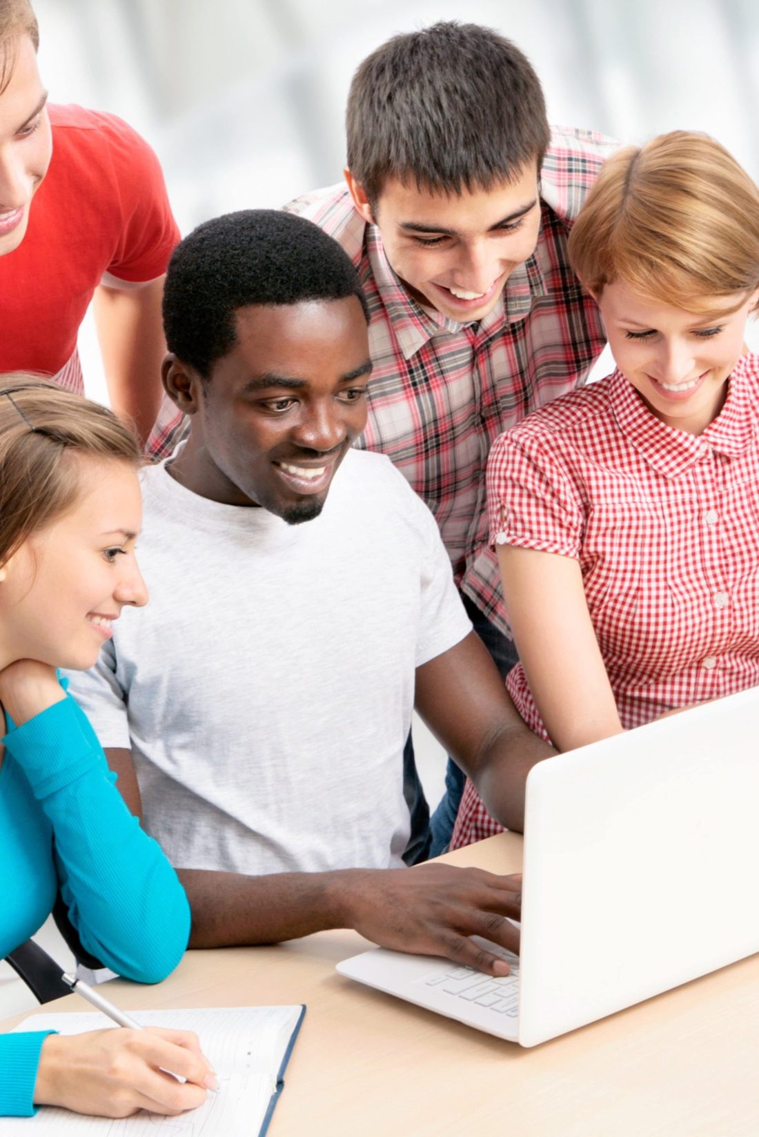 A group of people gathered around a laptop